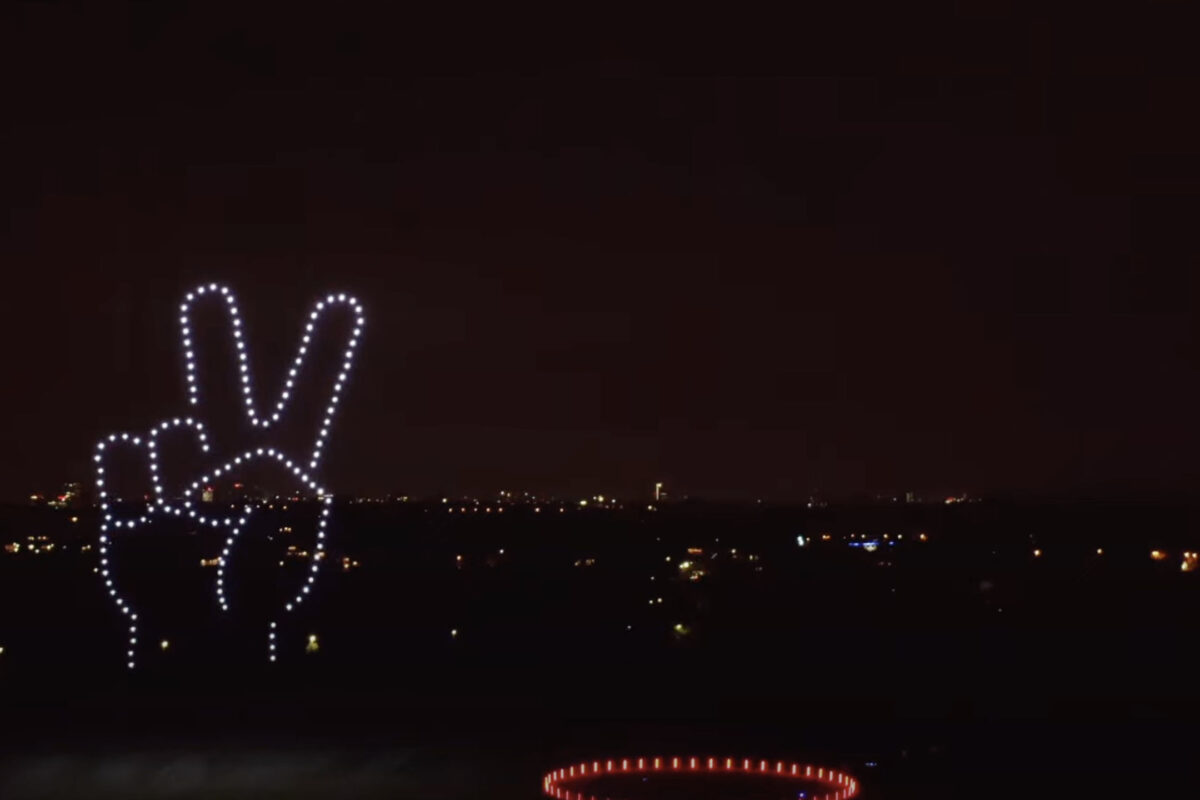 Synchronisierte Drohnen formen ein markenbezogenes Symbol am Himmel.