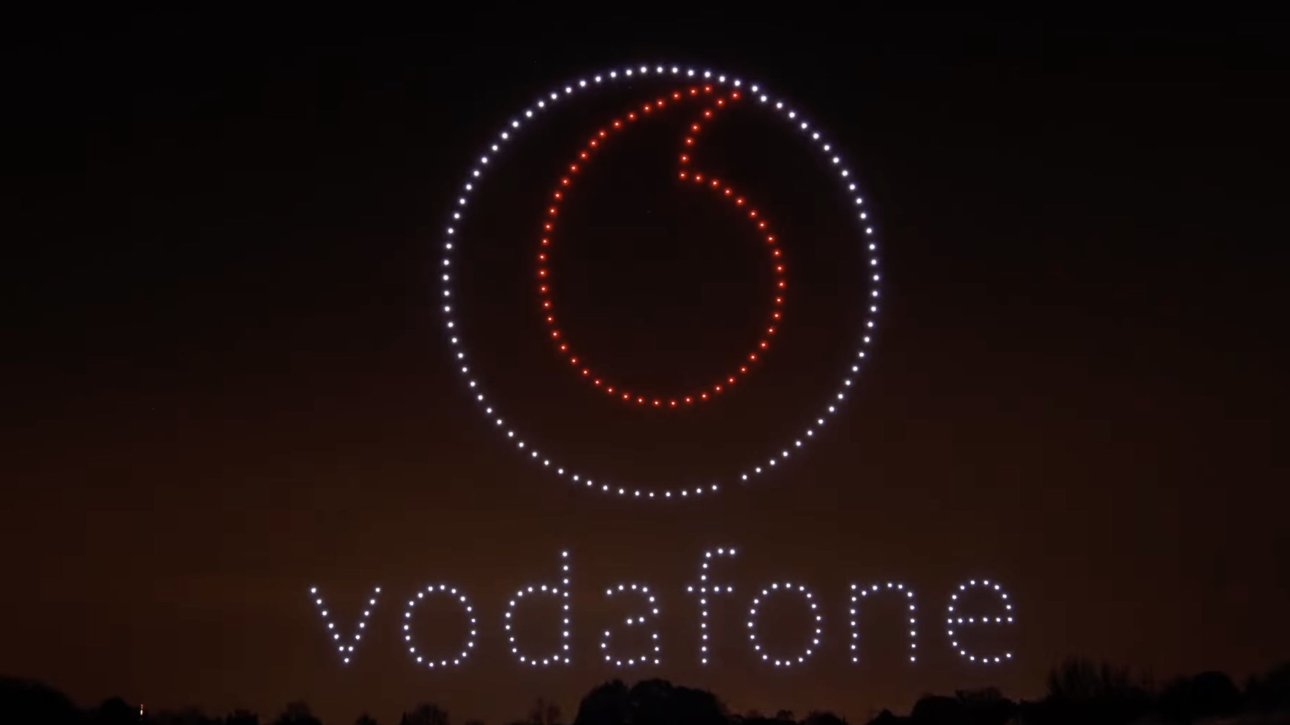Drohnenshow mit dynamischer Lichtformation als Markeninszenierung am Nachthimmel.