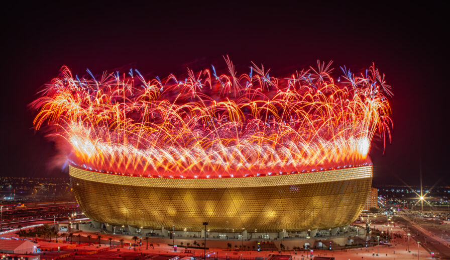 Großformatige Pyrotechnik integriert in die Architektur eines Stadions während einer Live-Veranstaltung.