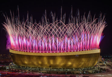 Pyrotechnische Effekte als Teil einer Stadion-Eröffnungszeremonie mit synchronisierten visuellen Elementen.