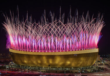 Pyrotechnische Effekte als Teil einer Stadion-Eröffnungszeremonie mit synchronisierten visuellen Elementen.