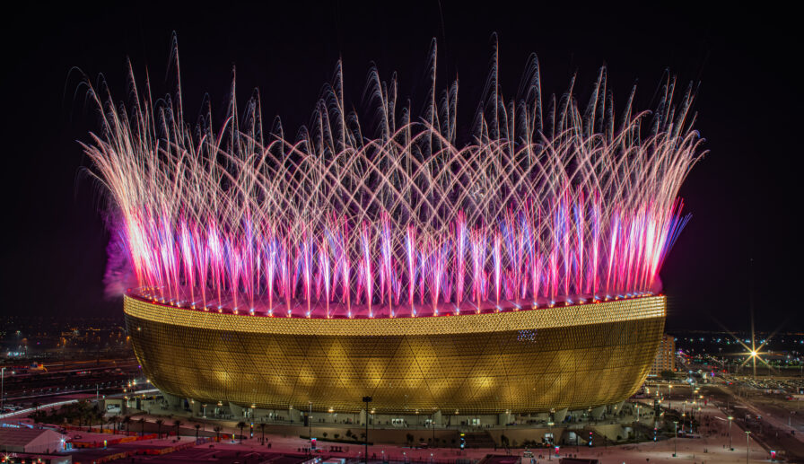 Pyrotechnische Effekte als Teil einer Stadion-Eröffnungszeremonie mit synchronisierten visuellen Elementen.