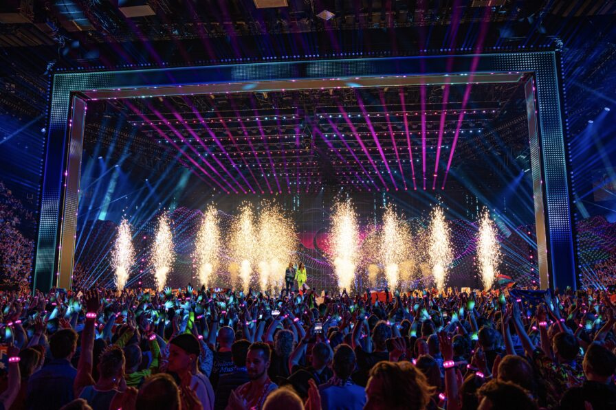 Gesamtansicht der ESC-Bühne 2025 mit integrierten Pyroeffekten in einer modernen Arena.