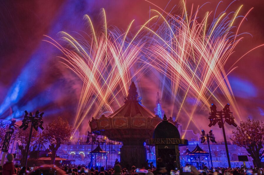 Pyrotechnische Effekte von Lunatx SFX steigen synchron zur Musik über dem Freizeitpark auf.