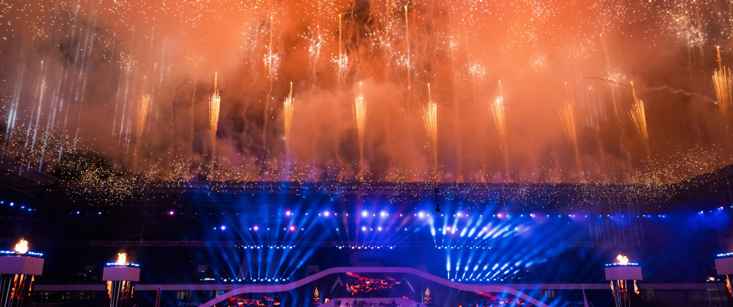 Blick auf synchrones Höhenfeuerwerk bei Nacht über der Arena während der Lunatx Pyroshow zur FISU-Eröffnungsfeier.