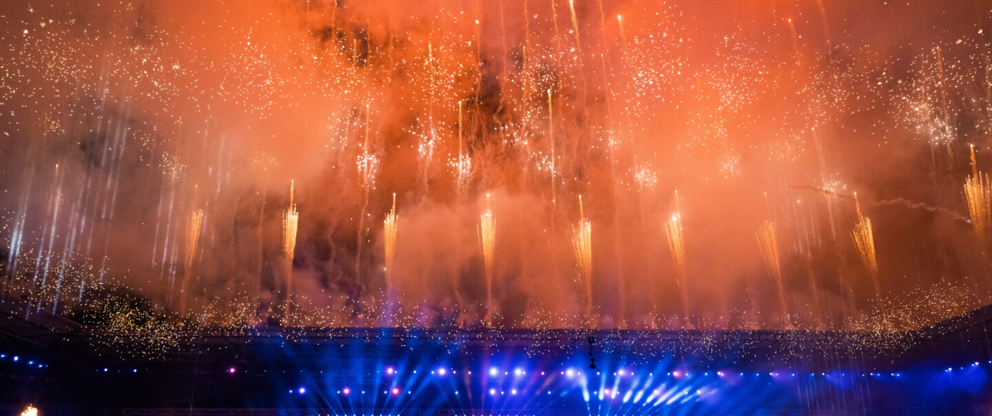 Blick auf synchrones Höhenfeuerwerk bei Nacht über der Arena während der Lunatx Pyroshow zur FISU-Eröffnungsfeier.