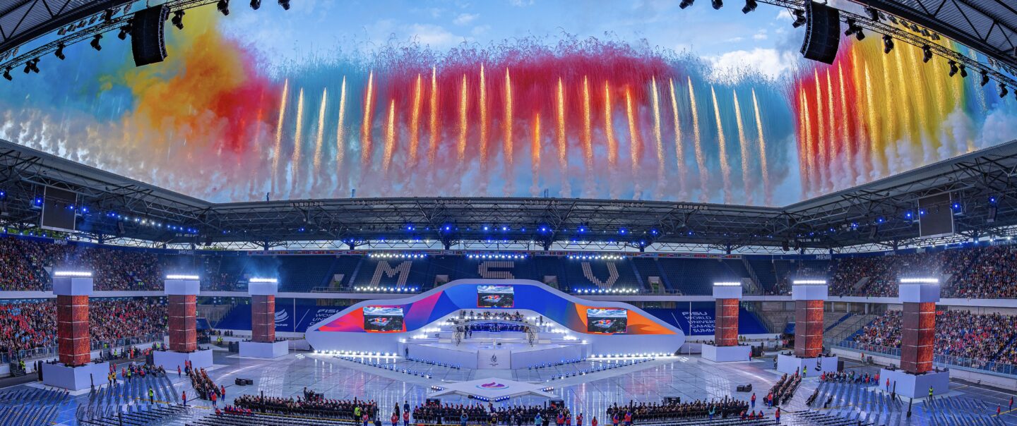 Tagespyrotechnik mit farbigen Rauchbildern über dem Spielfeld der FISU Opening Ceremony.