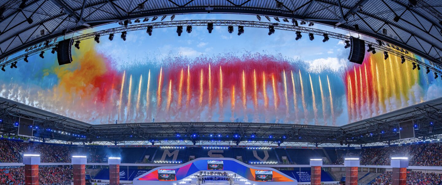 Tagespyrotechnik mit farbigen Rauchbildern über dem Spielfeld der FISU Opening Ceremony.