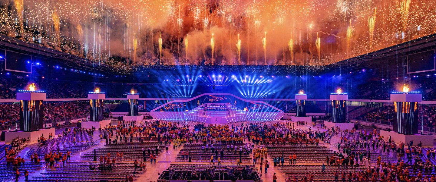 Panoramaaufnahme von Feuerwerksformationen mit mehrstufigen Höhenbildern über dem Stadion.