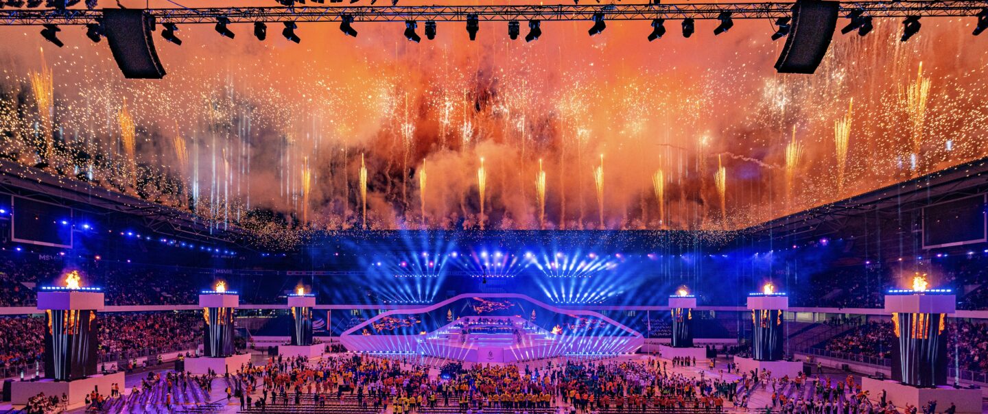 Panoramaaufnahme von Feuerwerksformationen mit mehrstufigen Höhenbildern über dem Stadion.