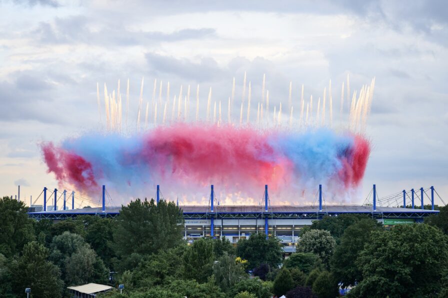 Luftaufnahme der Eröffnungsfeier im voll besetzten Stadion mit zentralem Lichteffekt und Pyrotechnik von Lunatx Pyroshow.