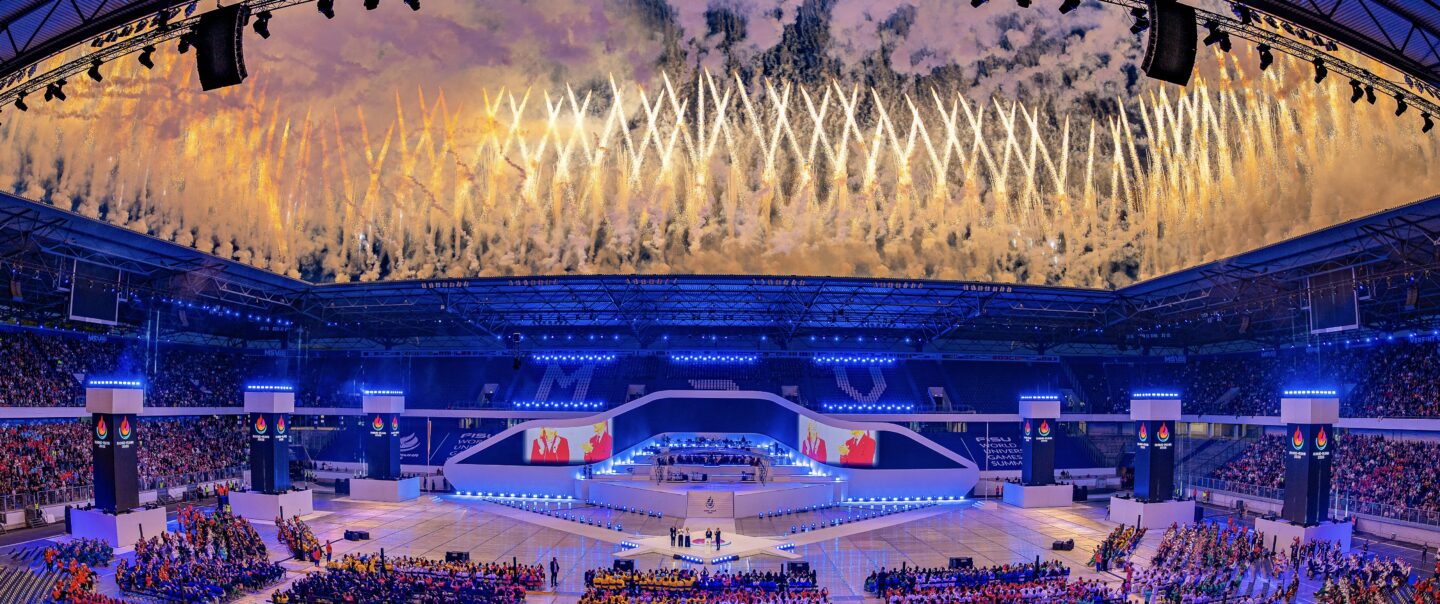 Synchron gezündete Boden- und Höhenpyrotechnik mit klaren Linien und symmetrischer Anordnung bei einer Lunatx Pyroshow im Stadion.