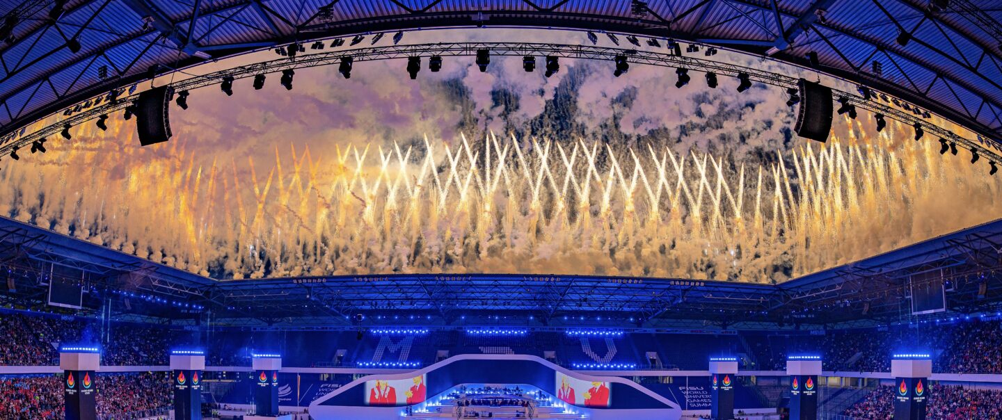 Synchron gezündete Boden- und Höhenpyrotechnik mit klaren Linien und symmetrischer Anordnung bei einer Lunatx Pyroshow im Stadion.