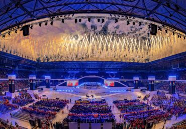 Synchron gezündete Boden- und Höhenpyrotechnik mit klaren Linien und symmetrischer Anordnung bei einer Lunatx Pyroshow im Stadion.