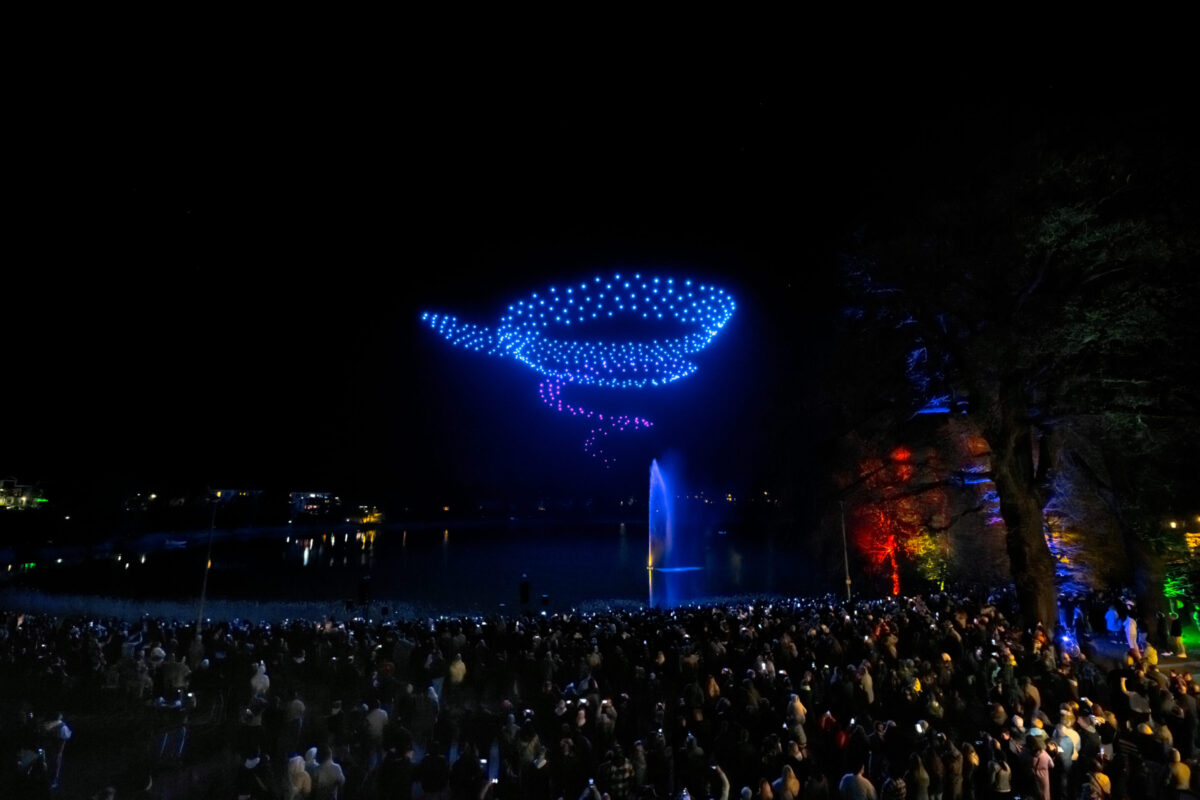 Tausende Zuschauer erleben die Drohnenshow am Seeufer