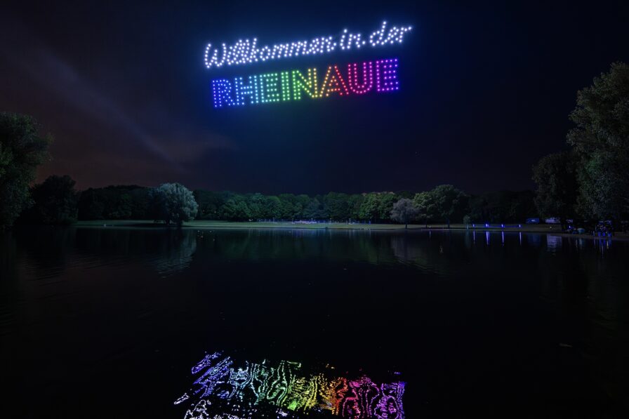 Synchronisierte Drohnenformationen über dem Rhein während einer Open-Air-Veranstaltung in Bonn