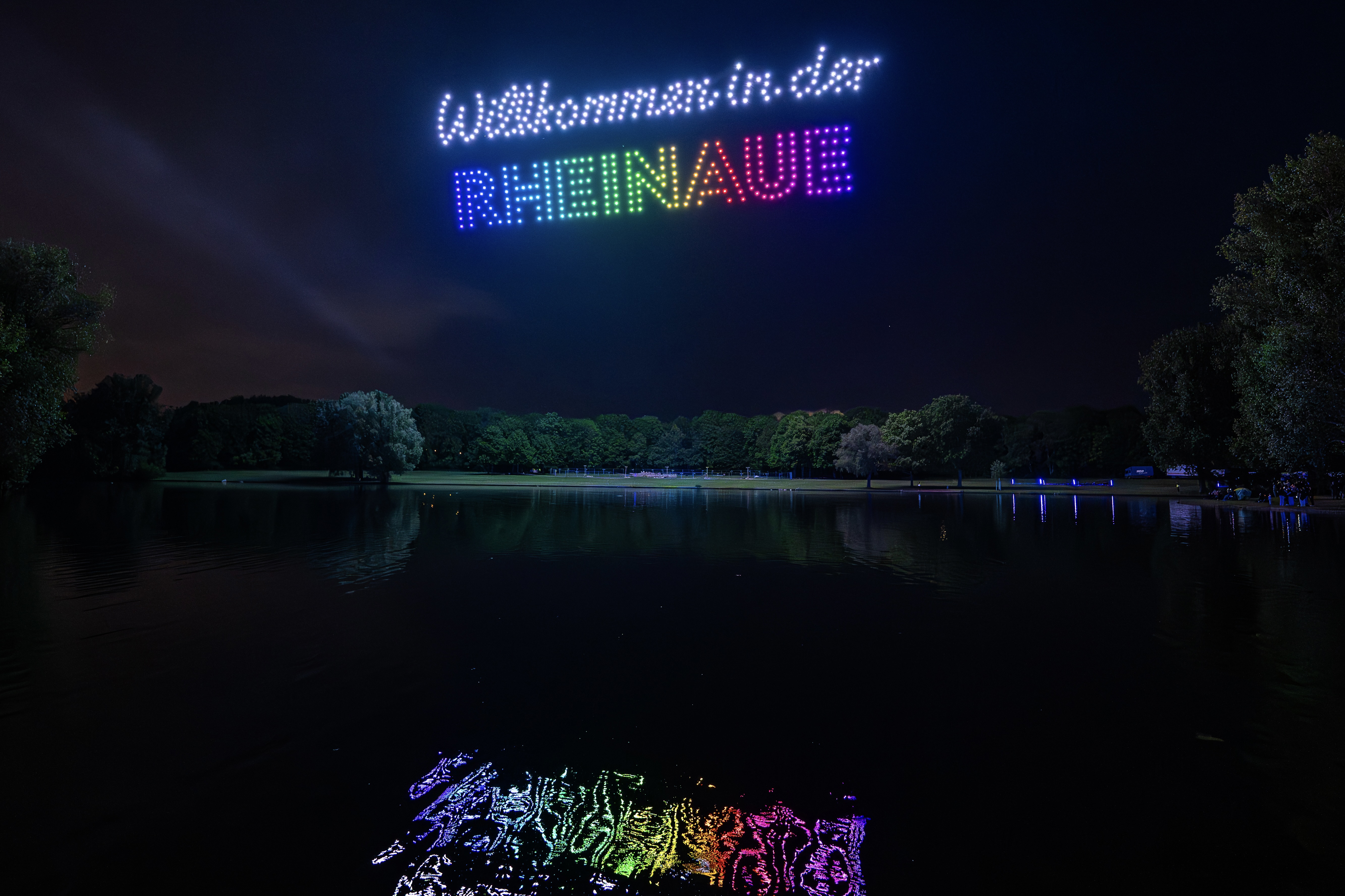 Synchronisierte Drohnenformationen über dem Rhein während einer Open-Air-Veranstaltung in Bonn