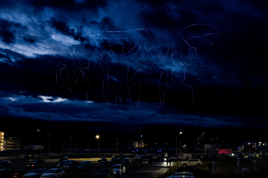 Drohnen bilden ein leuchtendes Vereinswappen am Himmel