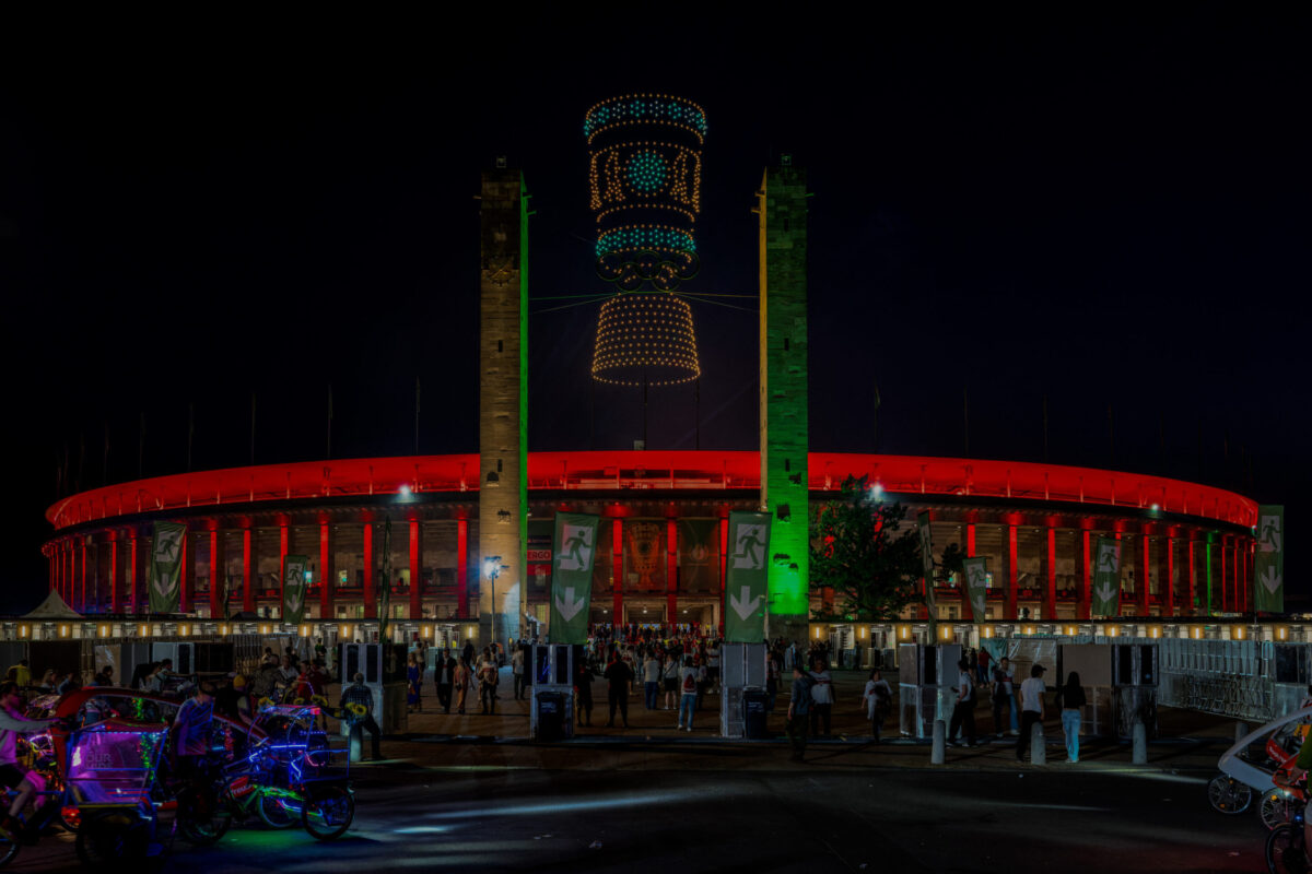 Showdrohnen bilden leuchtende Motive über dem Olympiastadion Berlin