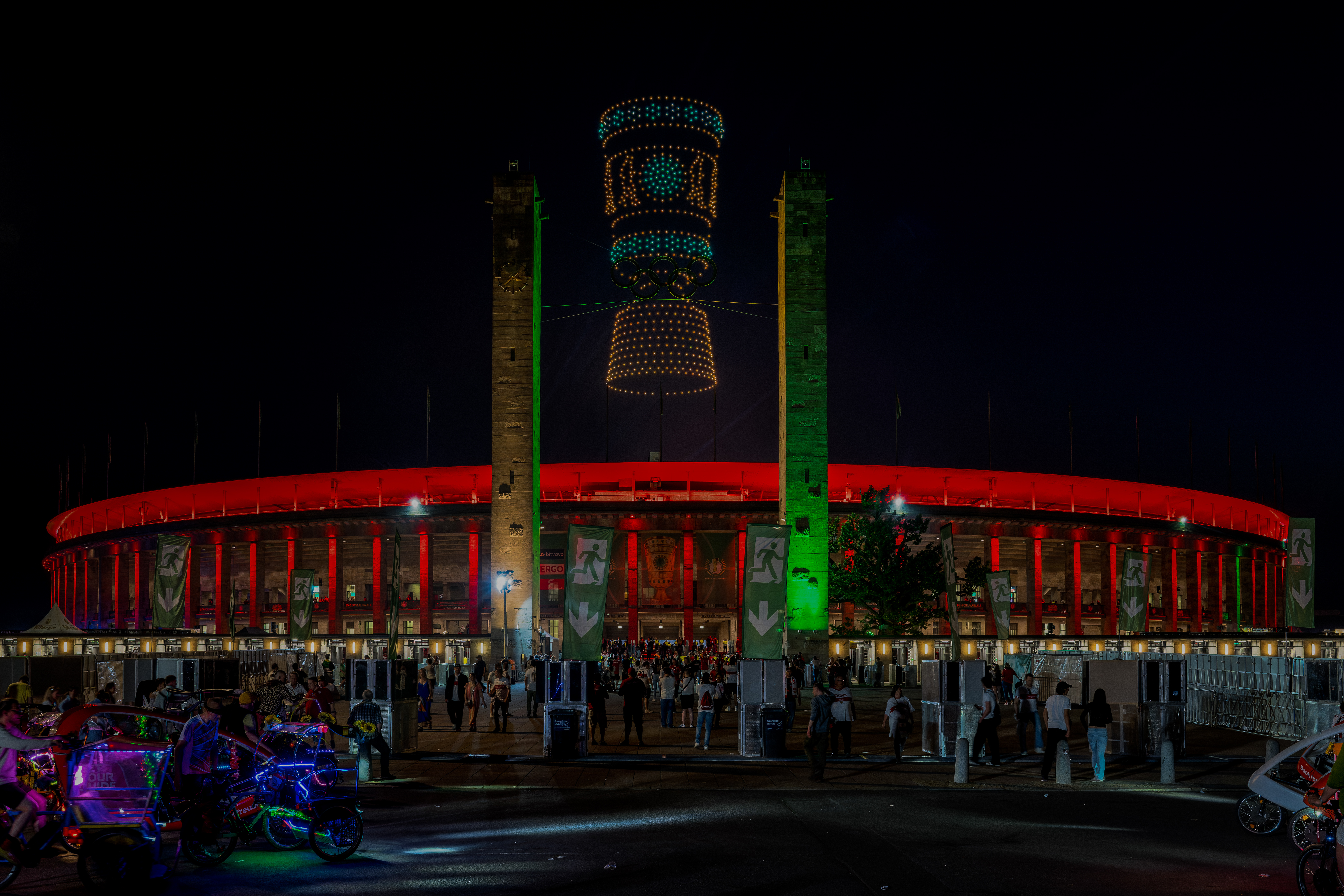 Showdrohnen bilden leuchtende Motive über dem Olympiastadion Berlin