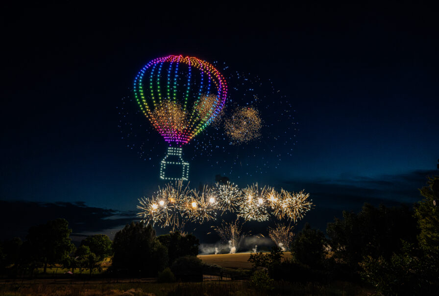 Drohnenshow mit 720 LED-Drohnen formt einen leuchtenden Heißluftballon am Nachthimmel