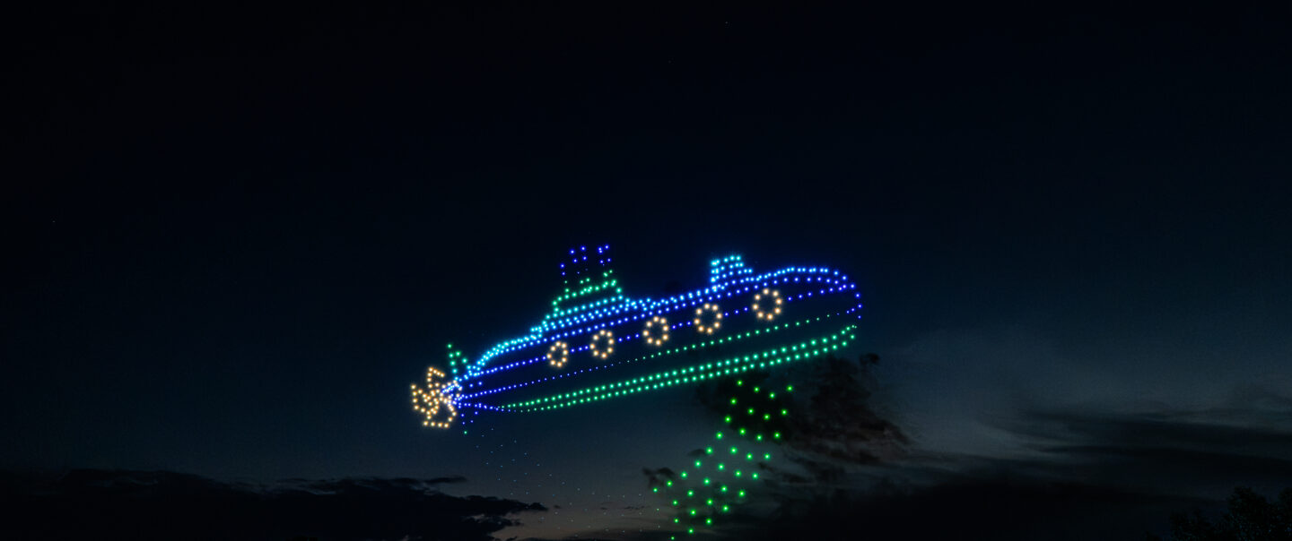 Drohnenshow mit 720 LED-Drohnen zeigt ein leuchtendes U-Boot am Nachthimmel