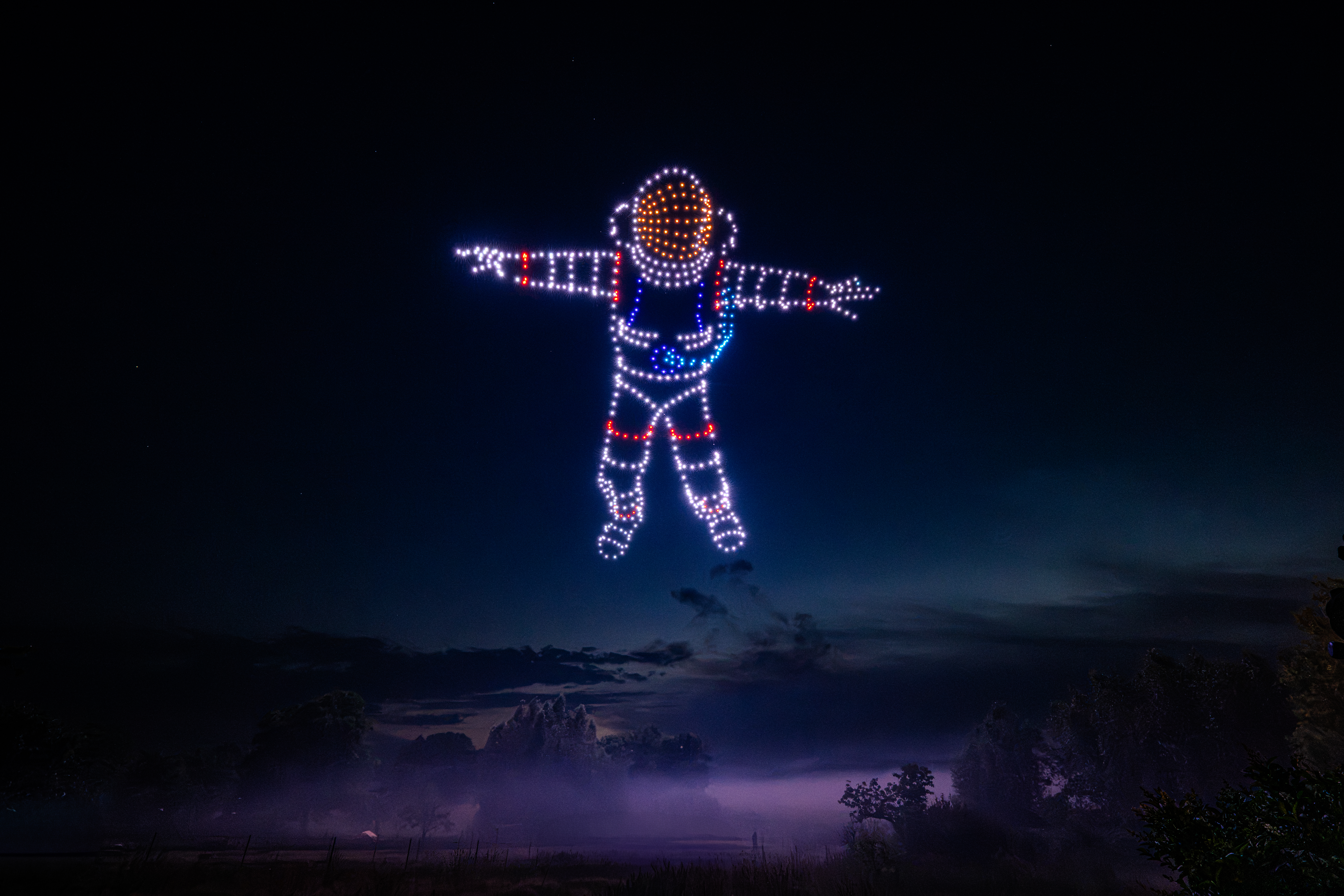 Drohnenshow mit 720 LED-Drohnen formt einen schwebenden Astronauten am Nachthimmel