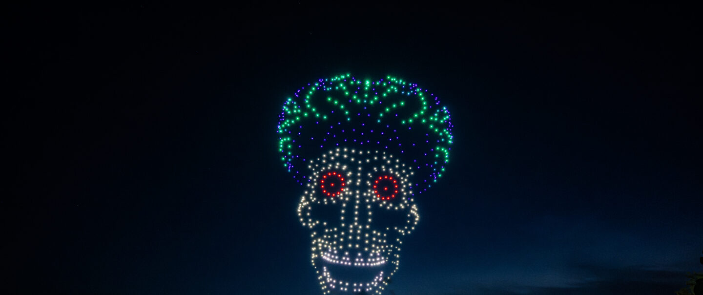 Drohnenshow mit 720 LED-Drohnen zeigt eine Mars-Attacks-inspirierte Alienfigur am Nachthimmel