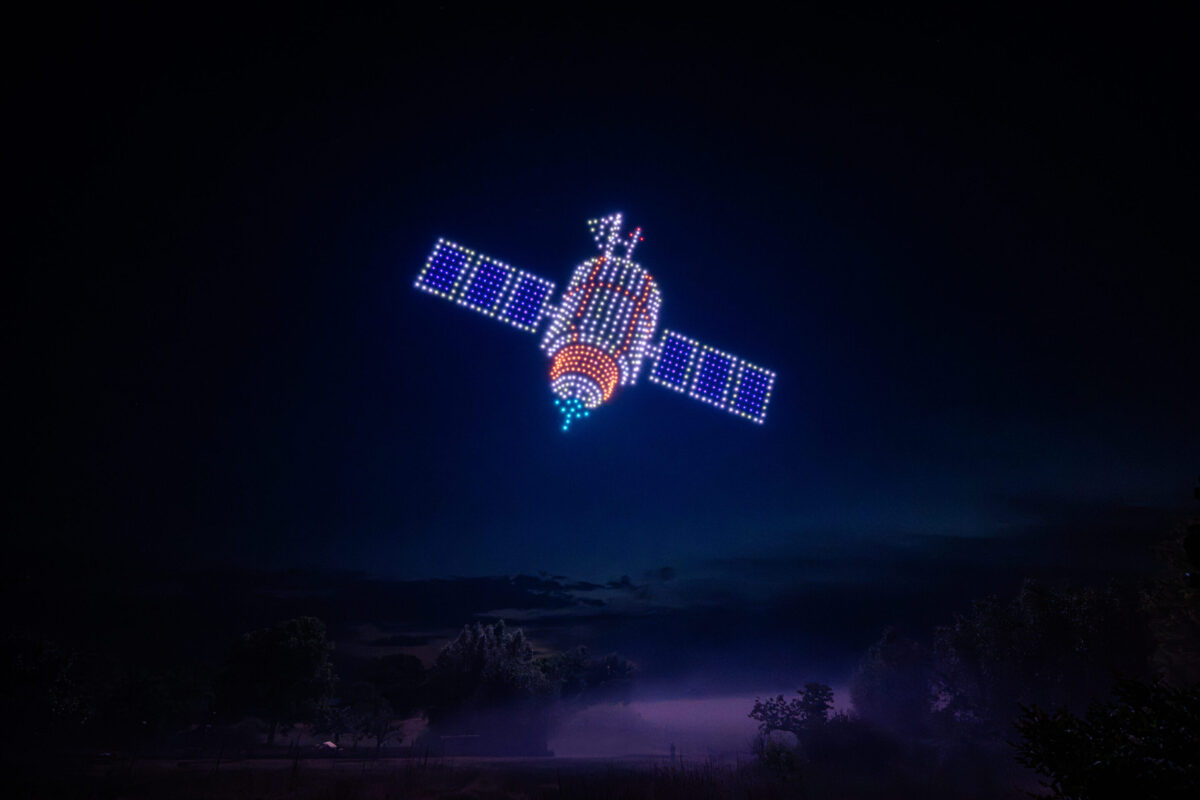 Drohnenshow mit 720 LED-Drohnen zeigt einen Satelliten am Nachthimmel