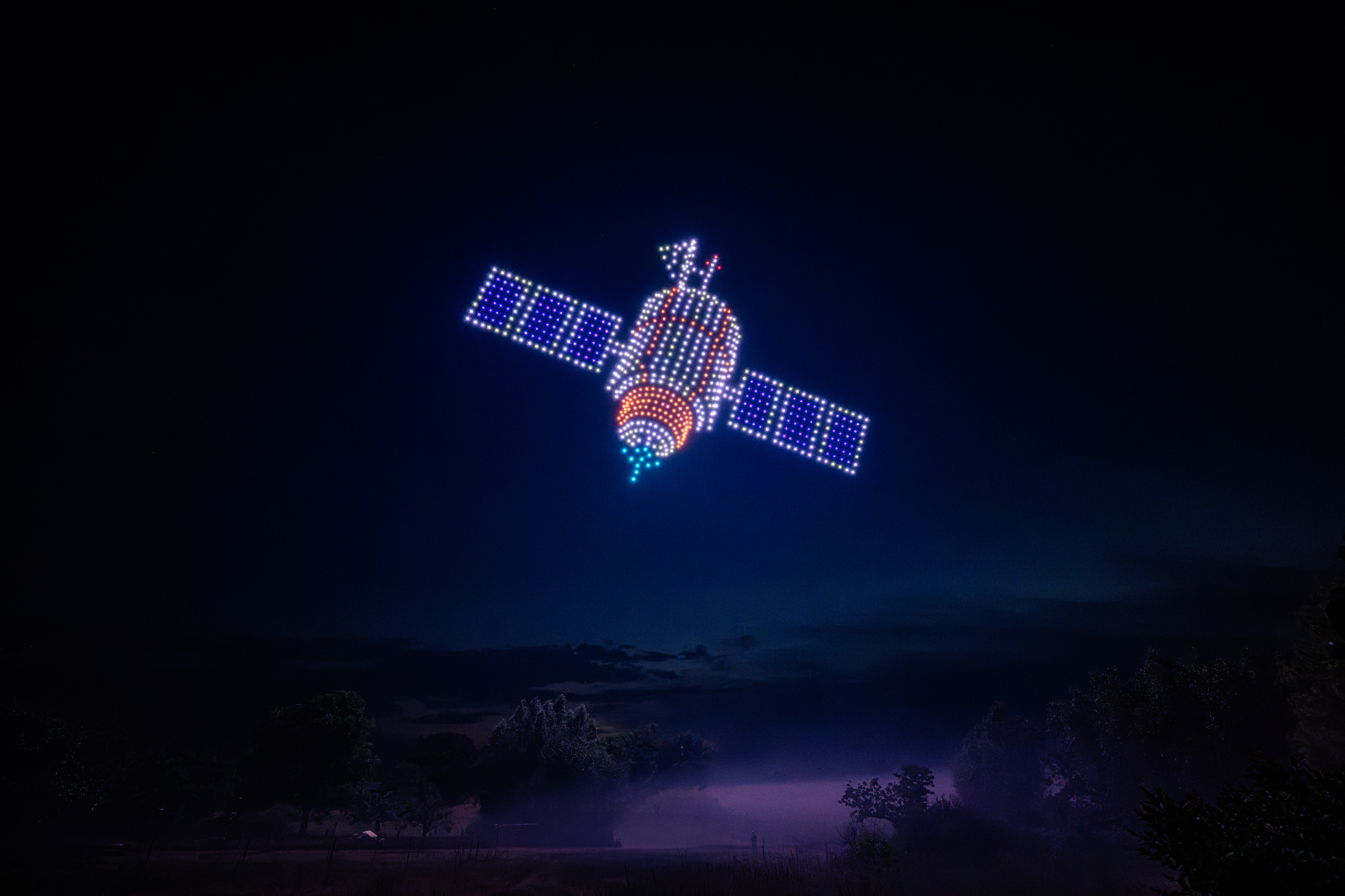 Drohnenshow mit 720 LED-Drohnen zeigt einen Satelliten am Nachthimmel