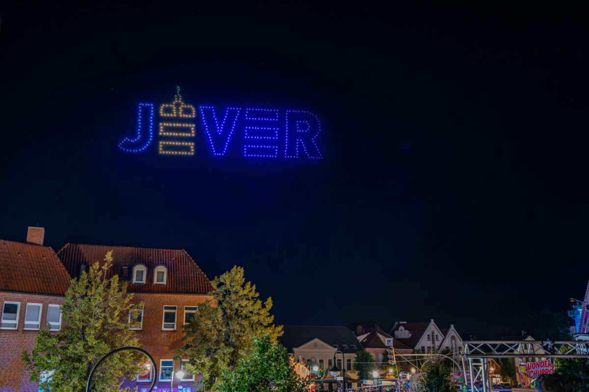 Stadtlogo Jever als leuchtende Drohnenformation am Nachthimmel